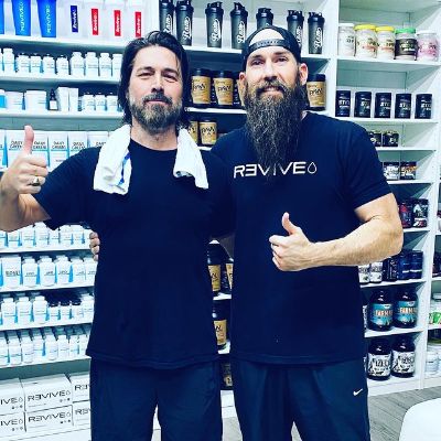 Both are posing with a thumbs up sign.